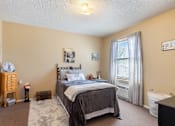 Thumbnail 11 of 16 - A Village Square Apartment bedroom with a bed and a window