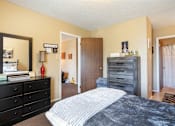 Thumbnail 10 of 16 - A Village Square Apartment bedroom with a bed and dresser and a closet