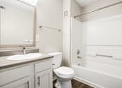 Thumbnail 18 of 18 - A white toilet sits next to a sink in a bathroom.