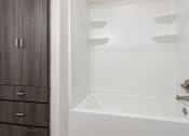 Thumbnail 7 of 37 - a bathroom with a white tub and a wooden cabinet