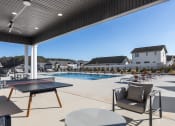 Thumbnail 13 of 48 - a large covered patio by the pool with ping pong and furniture at Sanctuary at Indian Creek rental homes in Madison, AL