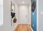 Thumbnail 22 of 48 - an entrance hall with overhead light, wood-style flooring, and a blue accent wall in a home at Sanctuary at Indian Creek