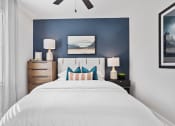 Thumbnail 23 of 48 - a bedroom with model furnishings and blue accent wall in a home at Sanctuary at Indian Creek