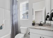 Thumbnail 24 of 48 - a bathroom with granite sink vanity, large mirror, window, toilet, and shower/tub