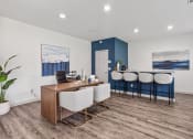 Thumbnail 10 of 28 - an office with a desk and chairs and a bar with a blue and white wall