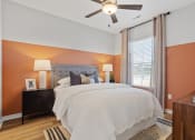 Thumbnail 34 of 48 - a large bedroom with a ceiling fan, accent wall, and model furnishings