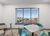 Thumbnail 18 of 37 - a classroom with a large window and a table and chairs