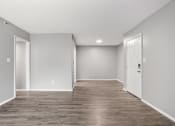 Thumbnail 22 of 28 - the spacious living room is empty and has a white door
