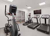 Thumbnail 24 of 37 - a gym with various exercise machines and a tv