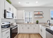 Thumbnail 46 of 48 - a large kitchen with white cabinets and stainless steel appliances in a rental home near Huntsville, AL