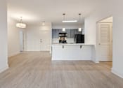 Thumbnail 4 of 37 - an open kitchen and living room with white walls and wood flooring