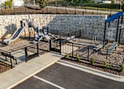 Thumbnail 27 of 37 - a playground with slides and benches in front of a stone wall