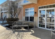 Thumbnail 2 of 24 - the well-kept entrance with benches at Algonquin Manor Senior Apartments for Rent