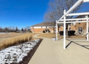 Thumbnail 20 of 24 - a neat walkway with snow on the ground at Algonquin Manor Senior Apartments