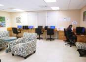 Thumbnail 8 of 18 - resident enjoying the computer lounge at B'nai B'rith I, II, & III apartments in deerfield beach