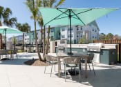 Thumbnail 15 of 48 - picnic tables and umbrellas beside luxury grilling areas at Lake Nona Concorde