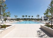 Thumbnail 11 of 48 - a swimming pool with chaise lounge chairs and trees at Lake Nona Concorde