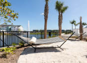 Thumbnail 13 of 48 - hammocks over sandy area beside Lake Nona Concorde's fenced pond