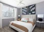 Thumbnail 40 of 48 - bedroom with wood-style floors, large window, and ceiling fan at Lake Nona Concorde Apartments