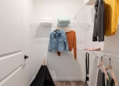 Thumbnail 43 of 48 - a walk in closet with built-in shelving and model clothing at Lake Nona Concorde