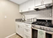 Thumbnail 19 of 32 - An apartment kitchen with stainless steel appliances and granite countertops at The Oasis Apartments in Daytona Beach, FL