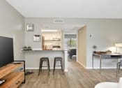 Thumbnail 17 of 32 - a living room with a kitchen in the background in The Oasis Daytona's model apartment