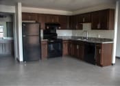 Thumbnail 8 of 12 - an empty kitchen with black appliances and wooden cabinets