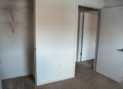 Thumbnail 10 of 12 - a room with a closet and a mirror in it