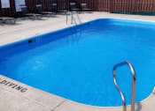 Thumbnail 2 of 8 - a large, blue swimming pool and a sundeck with lounge chairs