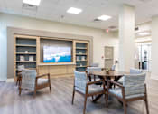 Thumbnail 2 of 26 - A conference room with a table, chairs, and a television on the wall.
