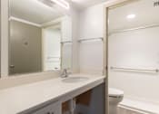 Thumbnail 18 of 26 - A bathroom with a sink, mirror, toilet and bathtub.