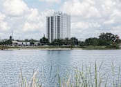 Thumbnail 25 of 26 - A large body of water with a building in the background.