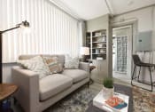 Thumbnail 10 of 24 - living room with built-in shelving, large window, and model furnishings