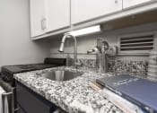 Thumbnail 6 of 24 - Kitchen with granite countertop, white cabinets, and stainless steel sink