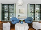 Thumbnail 10 of 57 - a living room with blue chairs and a white table