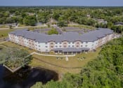 Thumbnail 57 of 57 - an aerial view of a building surrounded by trees and a body of water