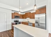 Thumbnail 16 of 57 - a kitchen with stainless steel appliances and wooden cabinets