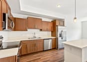 Thumbnail 17 of 57 - a kitchen with wooden cabinets and a stainless steel refrigerator