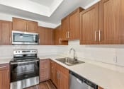 Thumbnail 19 of 57 - a kitchen with wooden cabinets and a sink and a stove