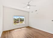 Thumbnail 20 of 57 - an empty living room with a window and a ceiling fan