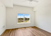 Thumbnail 22 of 57 - an empty living room with a window and wood floors