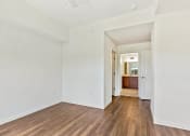 Thumbnail 23 of 57 - a living room with white walls and wood floors