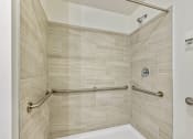 Thumbnail 26 of 57 - a spacious shower with grab bars in a bathroom