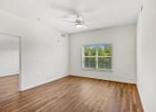Thumbnail 31 of 57 - an empty living room with a window and a ceiling fan