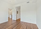 Thumbnail 34 of 57 - a living room with white walls and wood floors