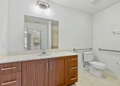 Thumbnail 36 of 57 - a bathroom with a toilet and a sink and a mirror