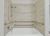 Thumbnail 39 of 57 - a bathroom with grab rails and a tub and a shower