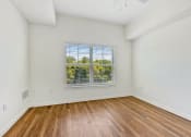 Thumbnail 40 of 57 - an empty living room with wood floors and a window