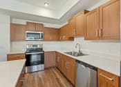 Thumbnail 41 of 57 - a kitchen with wooden cabinets and stainless steel appliances