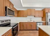 Thumbnail 42 of 57 - a kitchen with wooden cabinets and stainless steel appliances